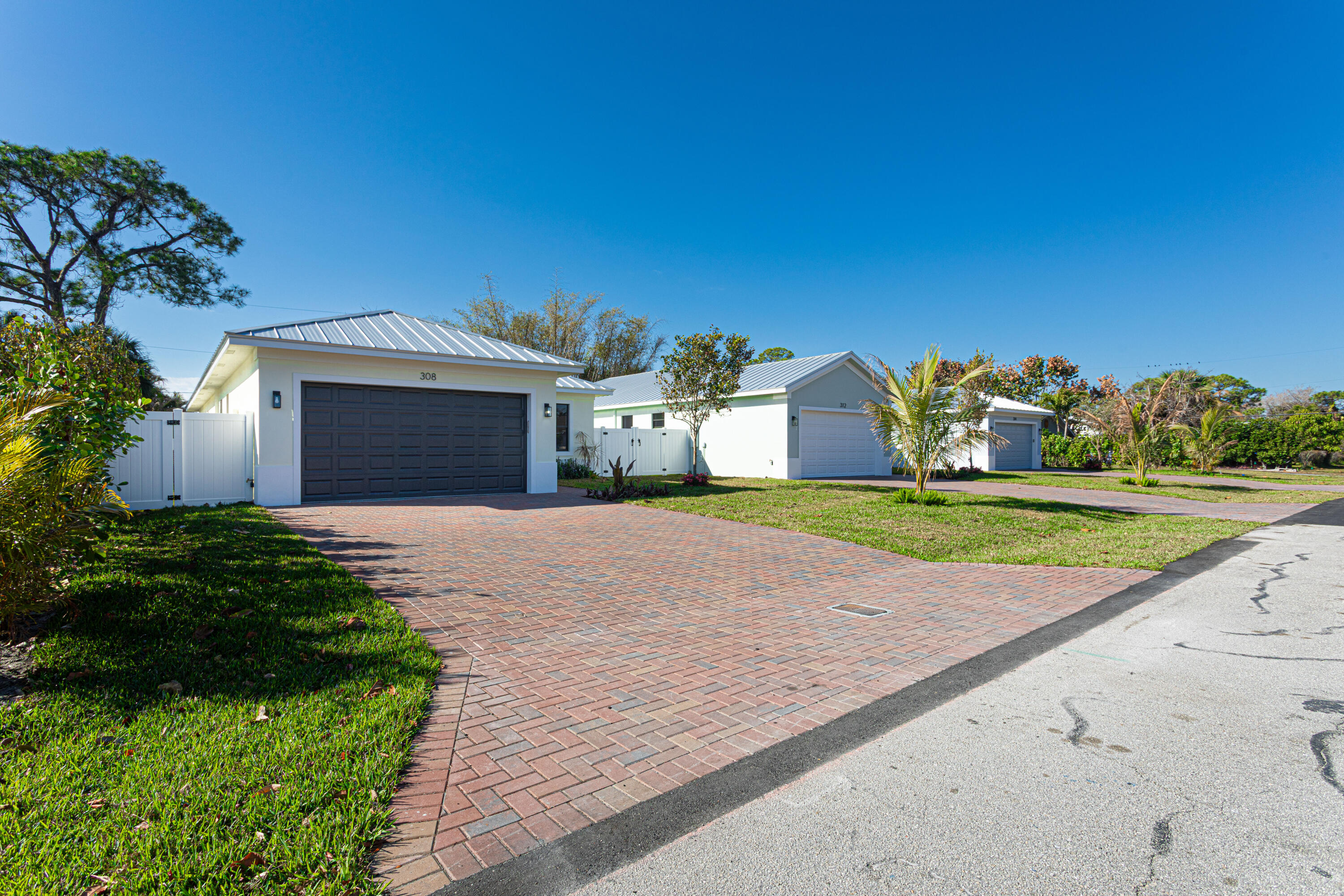 308 4th Street Jupiter, FL 33458 - Photo 2 of 51 a front view of a house with a yard and garage