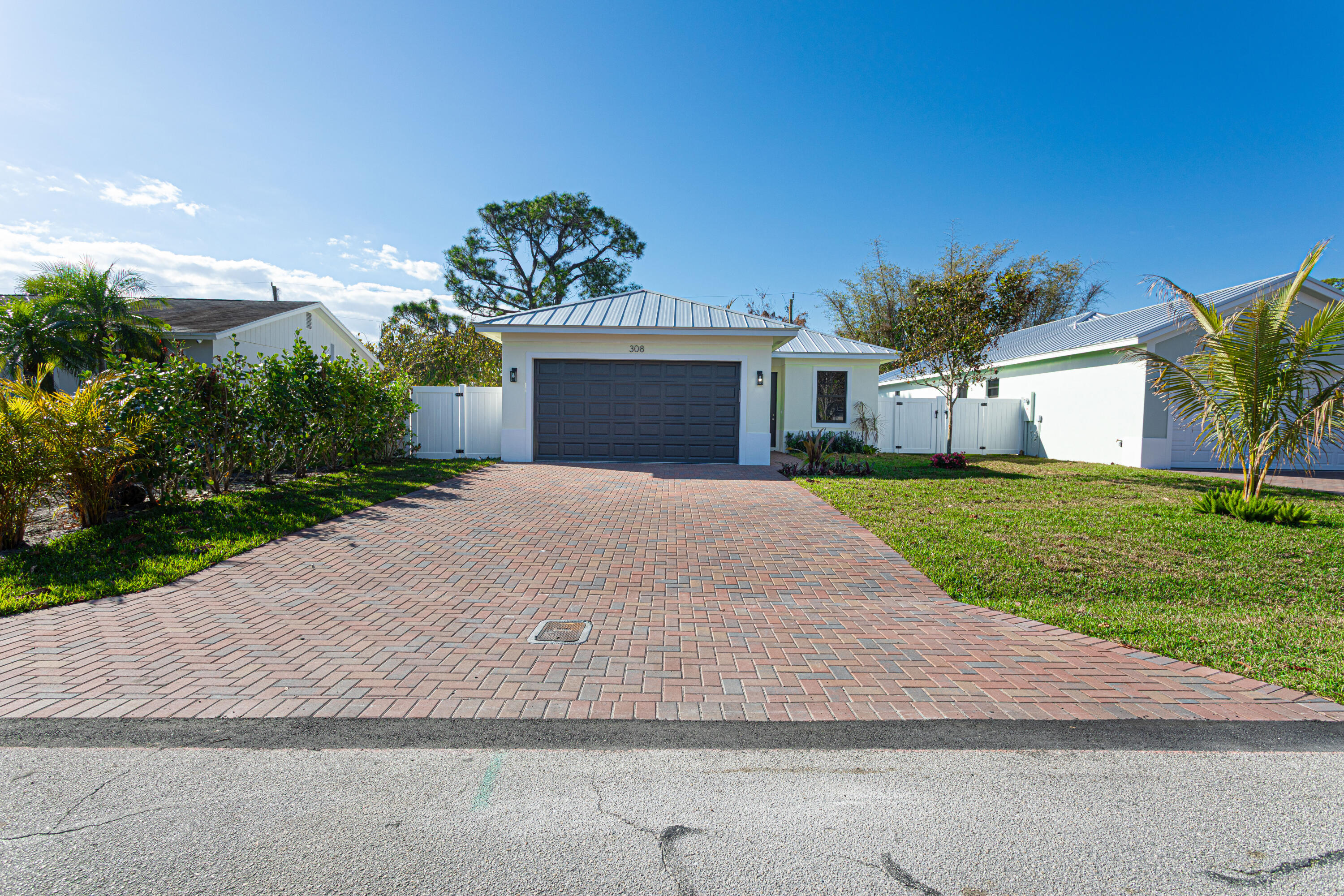 308 4th Street Jupiter, FL 33458 - Photo 3 of 51 a front view of a house with a yard and a garage