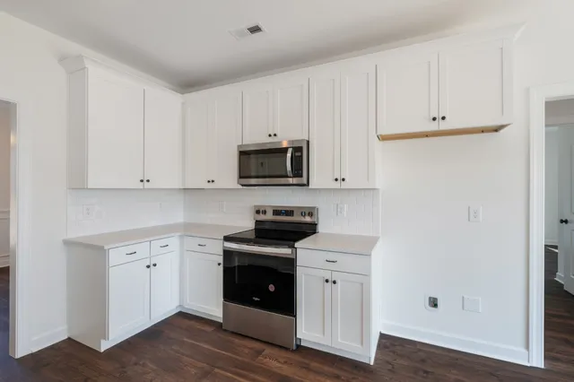 a kitchen with white cabinets and stainless steel appliances