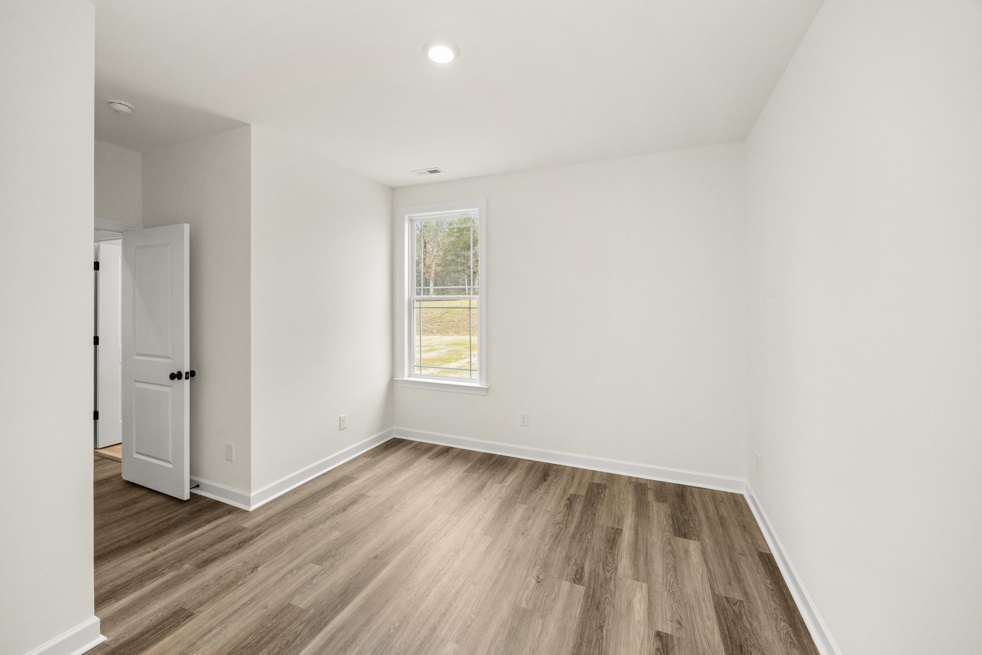 4002 Rampart Way Spring Hill Spring Hill, TN 37174 - Photo 20 of 42 a view of an empty room with wooden floor and a window