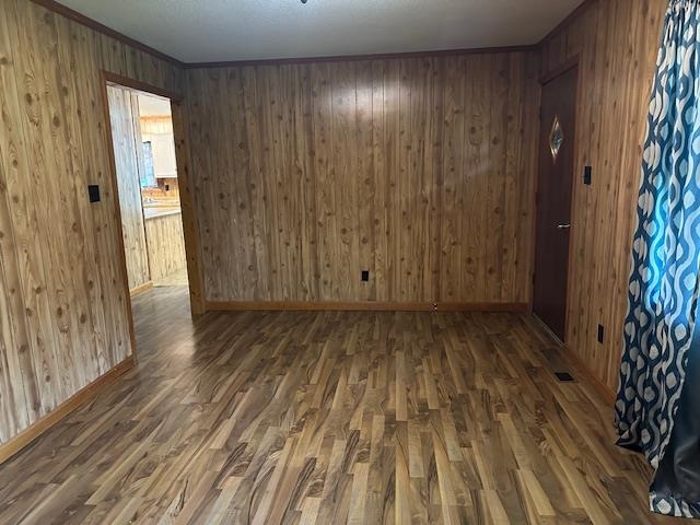 420 G B Plunk Road Selmer, TN 38375 - Photo 8 of 26 Unfurnished room with hardwood / wood-style flooring and wooden walls