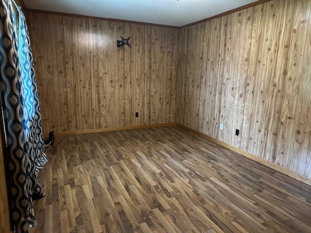 420 G B Plunk Road Selmer, TN 38375 - Photo 9 of 26 Unfurnished room featuring wood walls, wood-type flooring, and crown molding