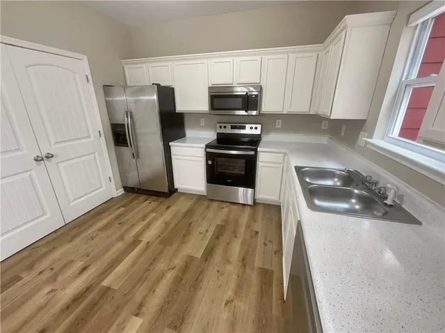 a kitchen with a sink a microwave a refrigerator and cabinets