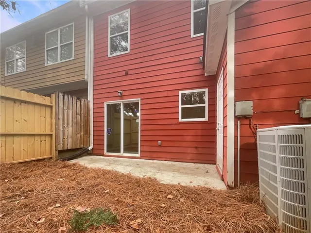 a view of a brick house with a large parking space