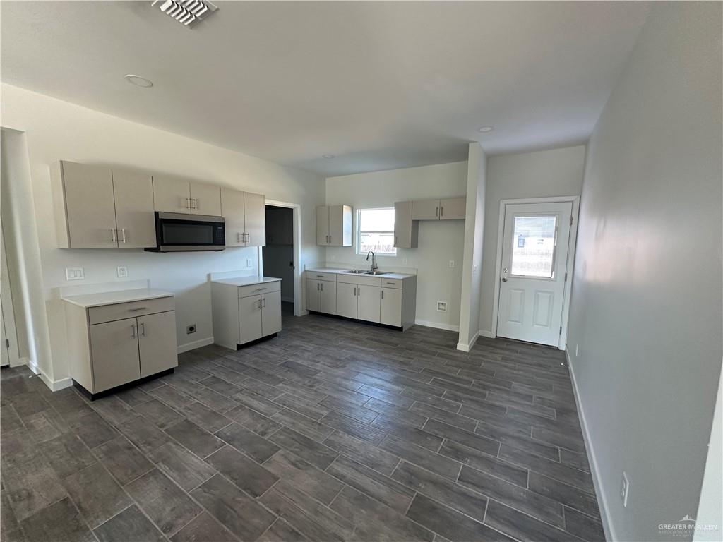 1805 Unity Drive Mercedes, TX 78570 - Photo 3 of 10 a large kitchen with a wooden floor and stainless steel appliances