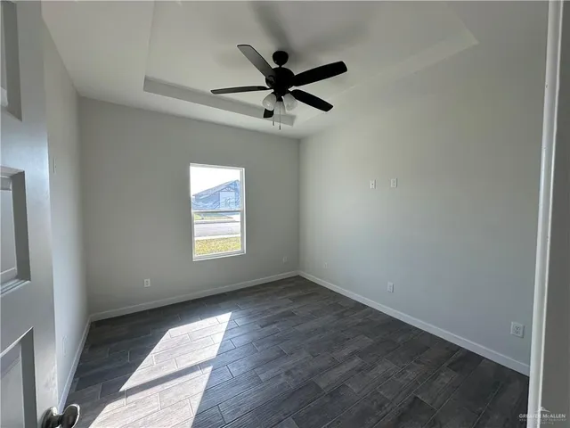 an empty room with a ceiling fan and window