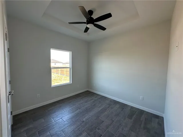 an empty room with a window and a ceiling fan