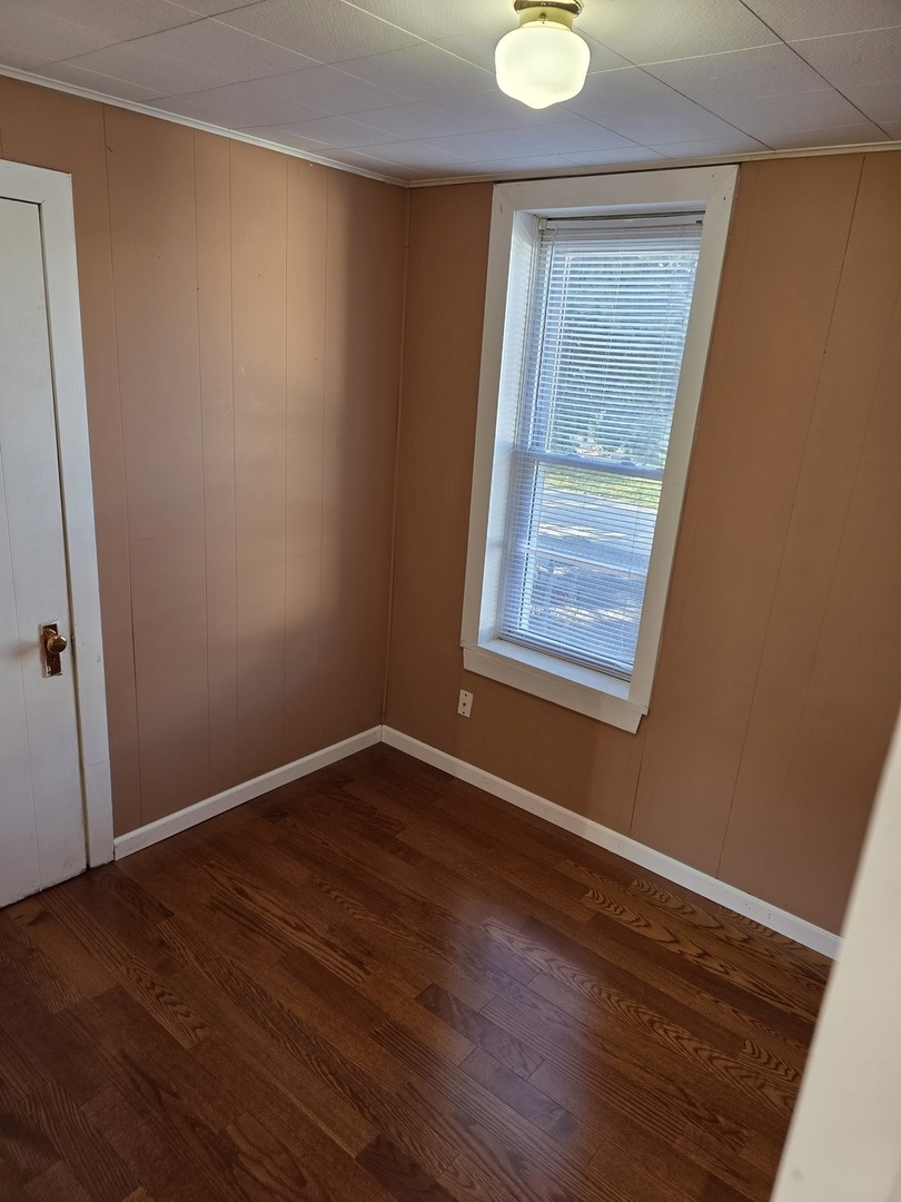 725 Chase Avenue Joliet, IL 60432 - Photo 6 of 15 an empty room with wooden floor and windows