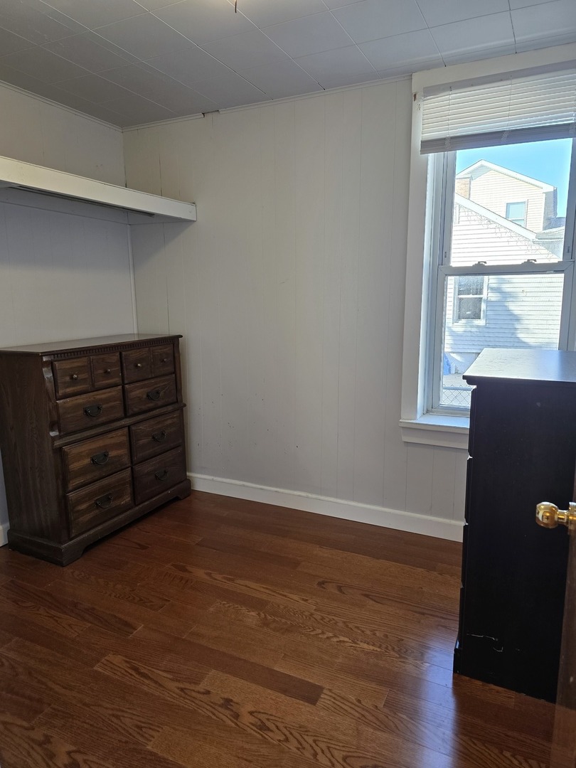 725 Chase Avenue Joliet, IL 60432 - Photo 7 of 15 a view of an empty room with wooden floor and a window