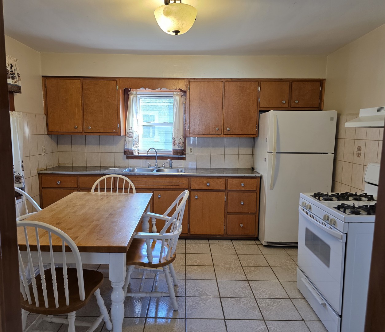 725 Chase Avenue Joliet, IL 60432 - Photo 9 of 15 a kitchen with a stove a sink and a refrigerator