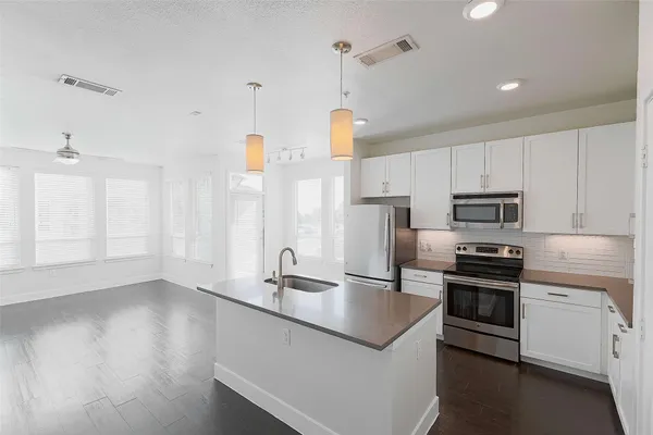 a kitchen with stainless steel appliances granite countertop a sink a stove and a refrigerator