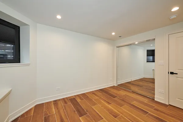 a view of an empty room with wooden floor and a flat screen tv
