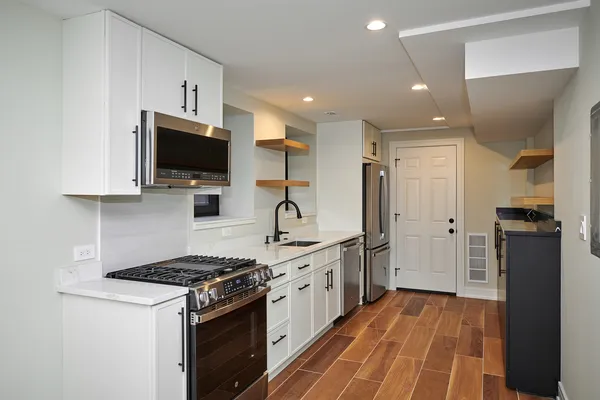 a kitchen with stainless steel appliances a stove refrigerator sink and microwave
