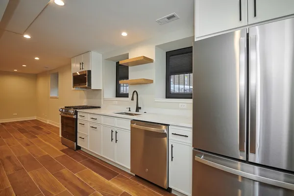 a kitchen with stainless steel appliances granite countertop a sink a stove and a refrigerator