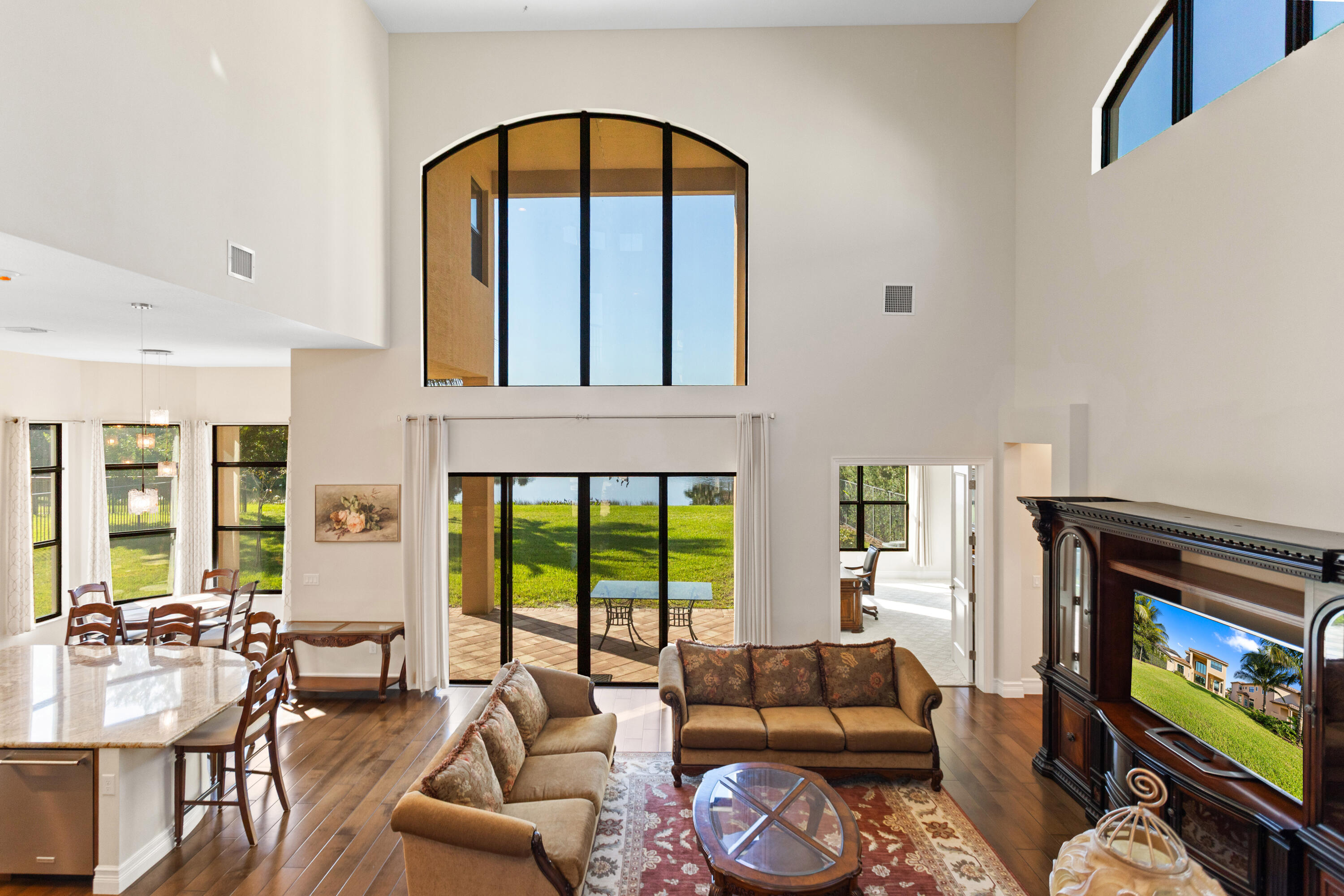 16743 Picardy Way Delray Beach, FL 33446 - Photo 31 of 79 a living room with furniture a floor to ceiling window and a flat screen tv