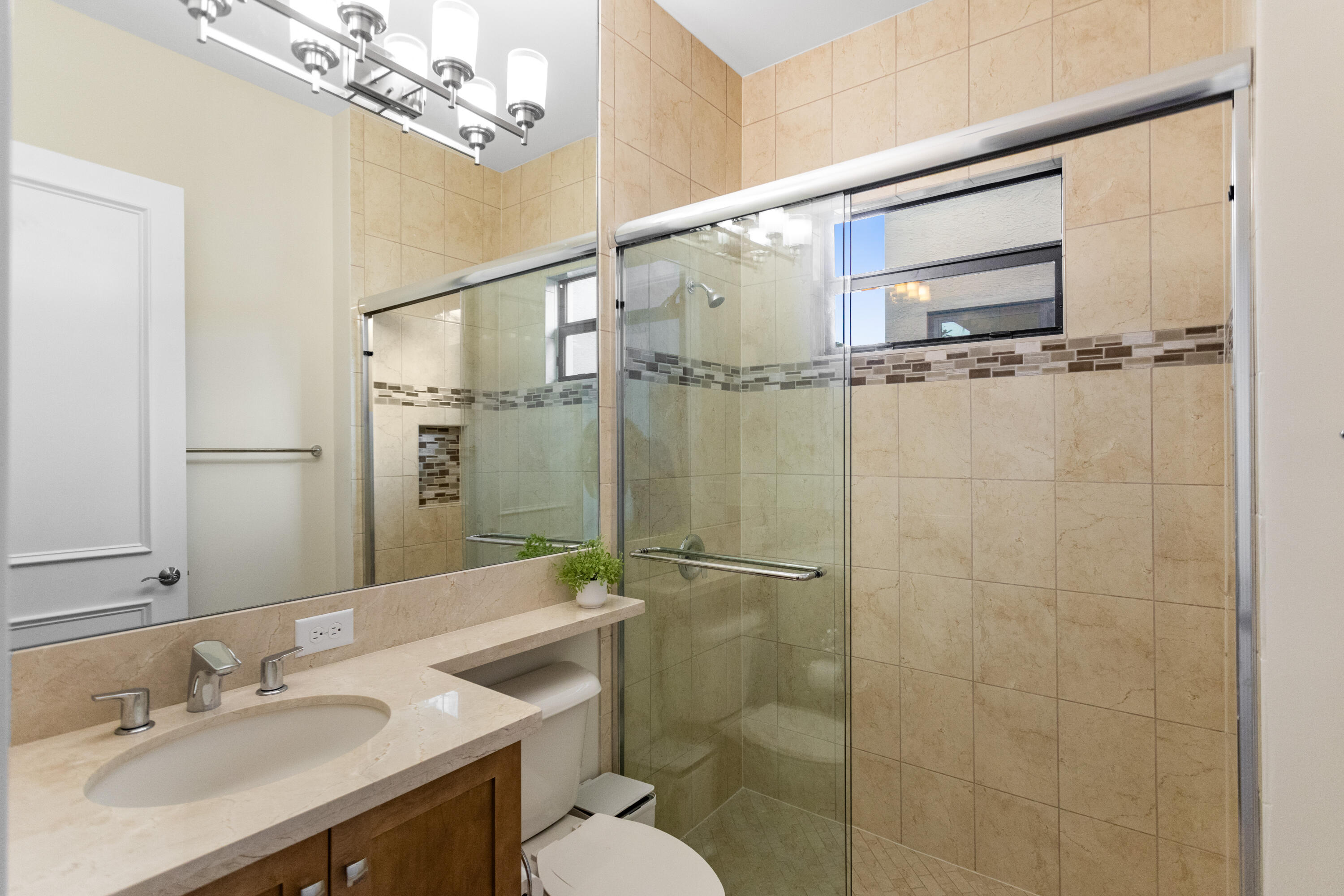 16743 Picardy Way Delray Beach, FL 33446 - Photo 43 of 79 a bathroom with a sink a toilet a mirror and shower