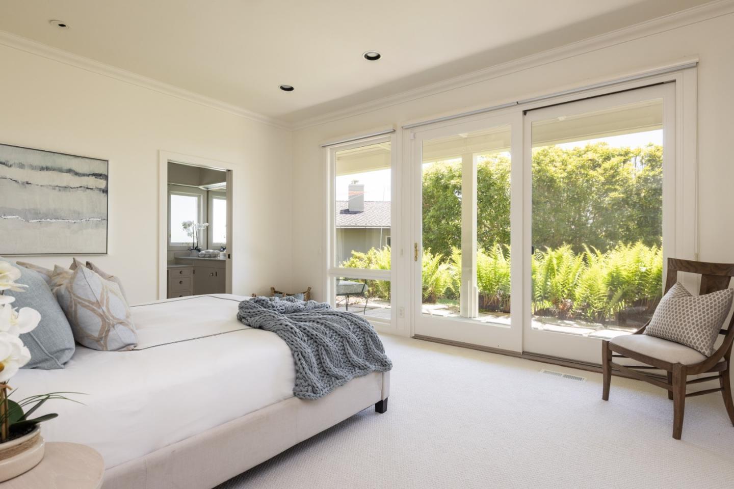 3307 17 Mile Drive, Unit 3 Pebble Beach, CA 93953 - Photo 20 of 42 a spacious bedroom with a bed and a large window