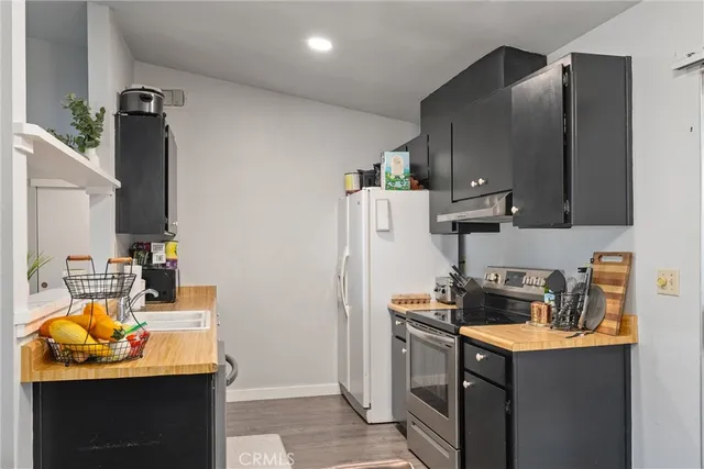 a kitchen with stainless steel appliances granite countertop a refrigerator and a stove top oven