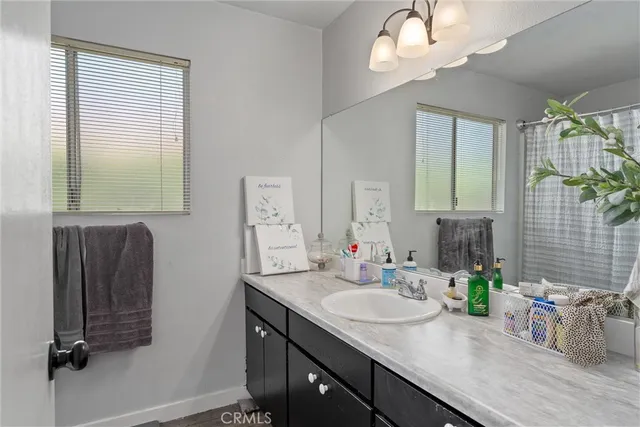 a bathroom with a granite countertop sink a mirror and a shower