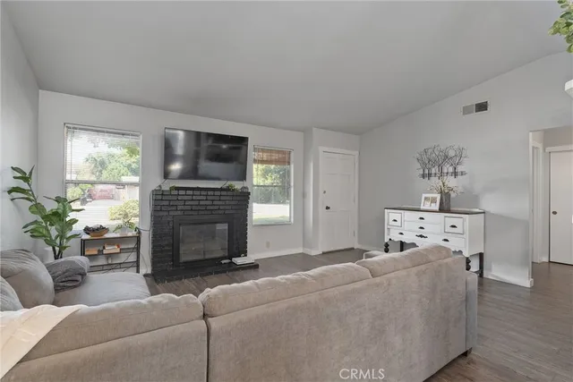 a living room with furniture a fireplace and a flat screen tv