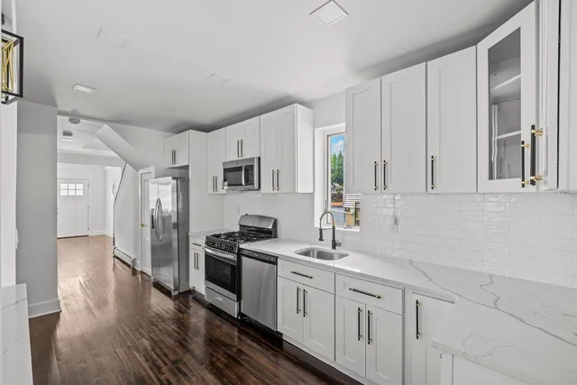 a kitchen with stainless steel appliances granite countertop a refrigerator and a stove top oven
