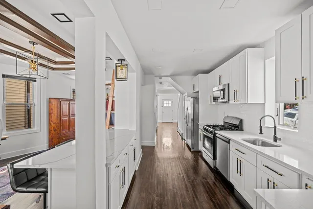 a kitchen with cabinets stainless steel appliances and wooden floor