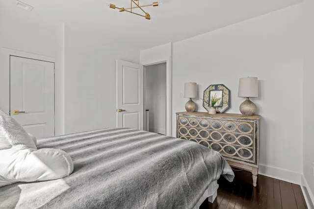 a bedroom with a bed a closet and windows