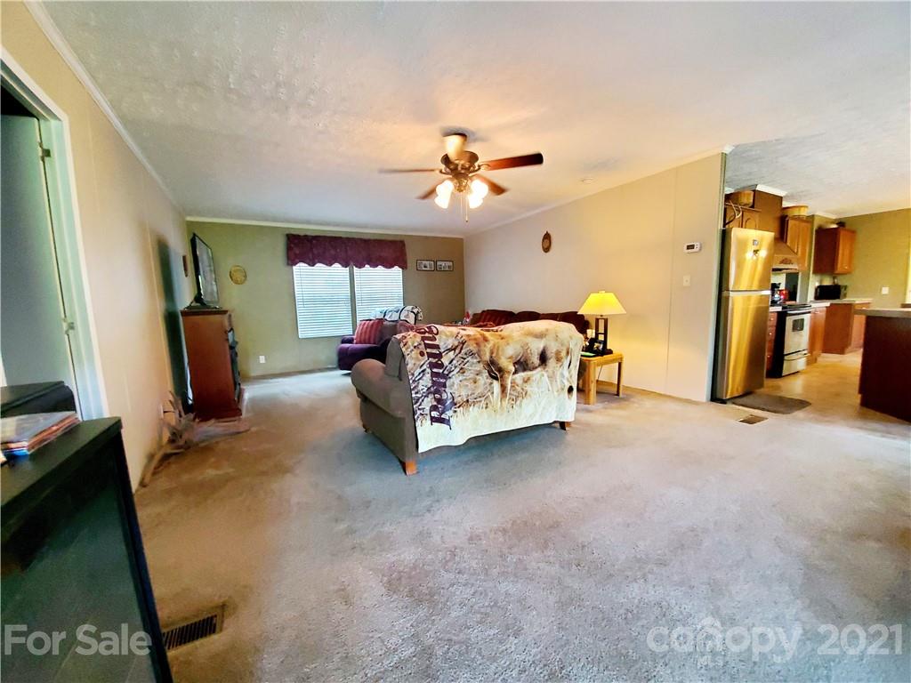 655 Sandy Bottom Road Marshall, NC 28753 - Photo 3 of 29 a bed room with a bed and a ceiling fan