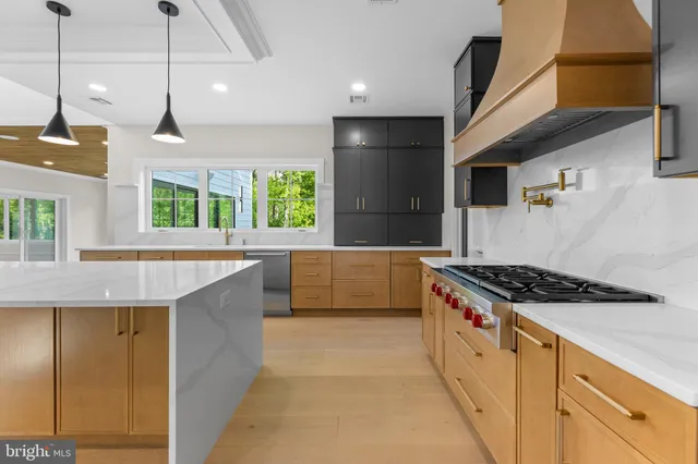 a large kitchen with stainless steel appliances a sink and a large window