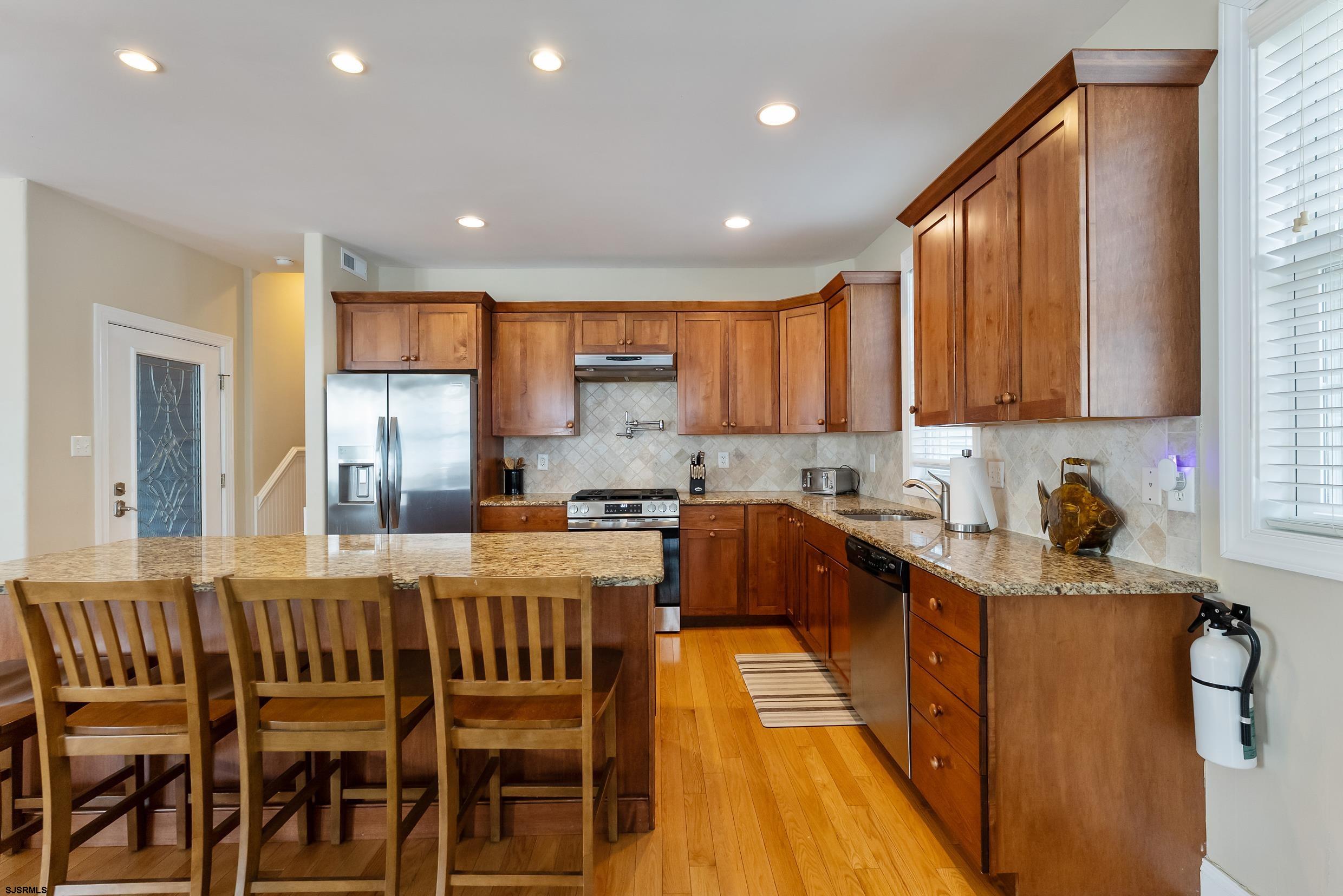 909 East 4th Street, Unit 1 Ocean City, NJ 08226 - Photo 11 of 47 a kitchen with stainless steel appliances granite countertop a refrigerator sink and cabinets