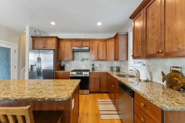 a kitchen with kitchen island granite countertop a sink stove and refrigerator