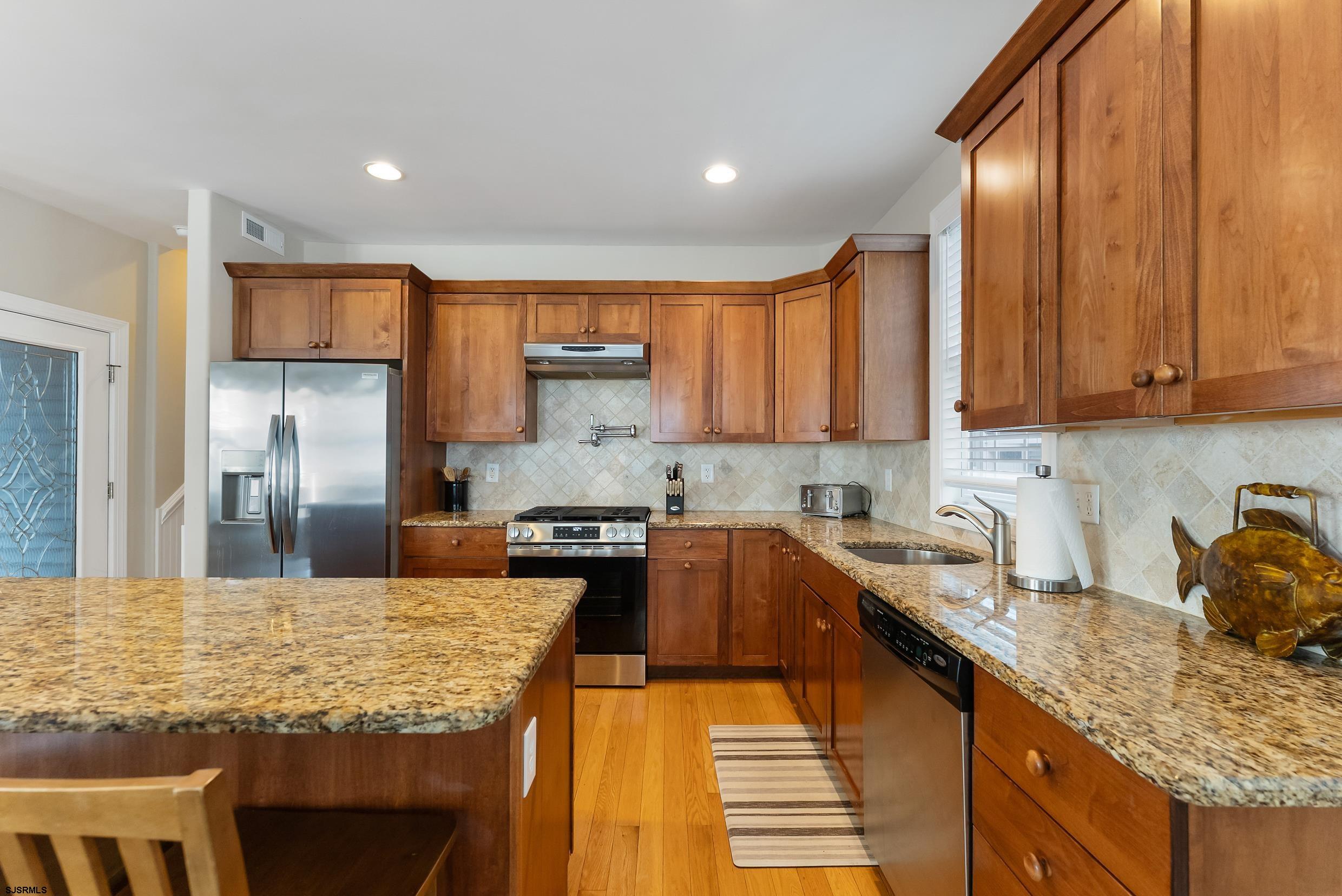 909 East 4th Street, Unit 1 Ocean City, NJ 08226 - Photo 12 of 47 a kitchen with kitchen island granite countertop a sink stove and refrigerator