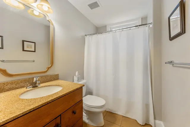 a bathroom with a granite countertop sink toilet and a mirror
