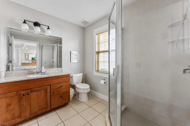 a spacious bathroom with a double vanity sink a toilet and a mirror