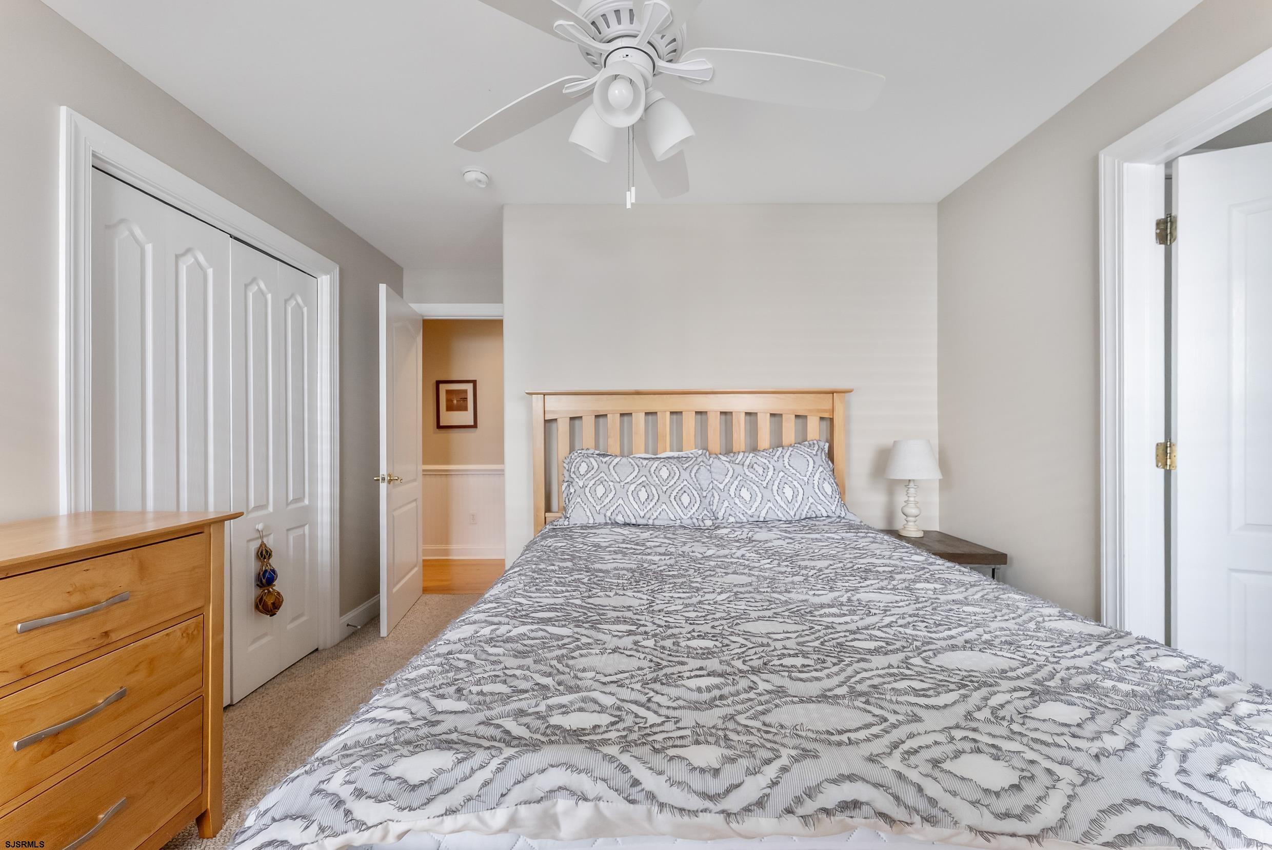 909 East 4th Street, Unit 1 Ocean City, NJ 08226 - Photo 26 of 47 a bedroom with a large bed and a chandelier