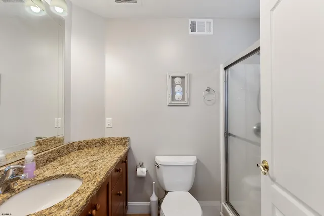 a bathroom with a granite countertop toilet sink and mirror