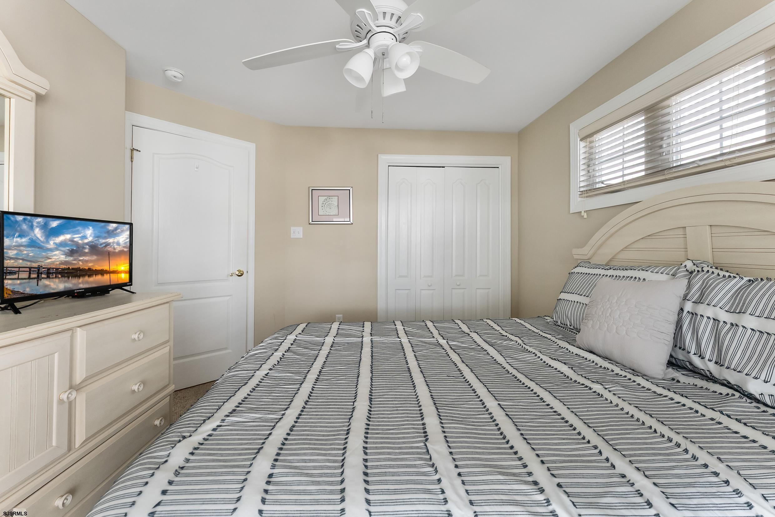 909 East 4th Street, Unit 1 Ocean City, NJ 08226 - Photo 32 of 47 a bedroom with a bed and a flat screen tv