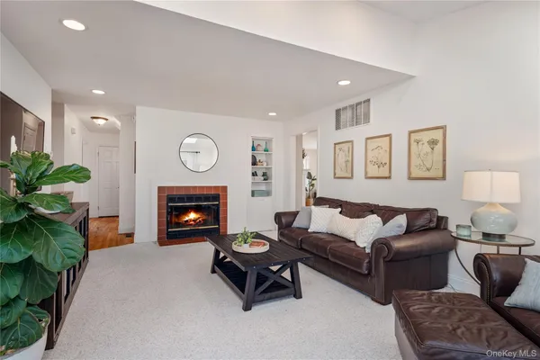 a living room with furniture a fireplace and a potted plant