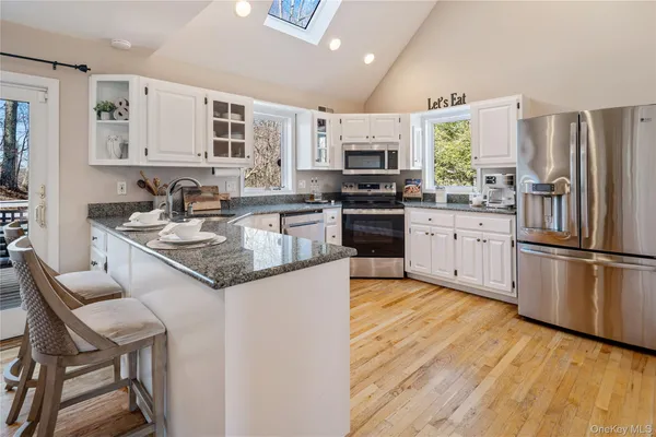 a kitchen with stainless steel appliances granite countertop a stove refrigerator sink and cabinets