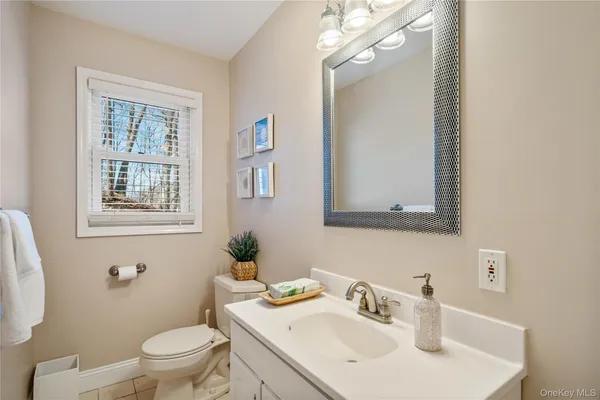a bathroom with a sink a toilet and mirror