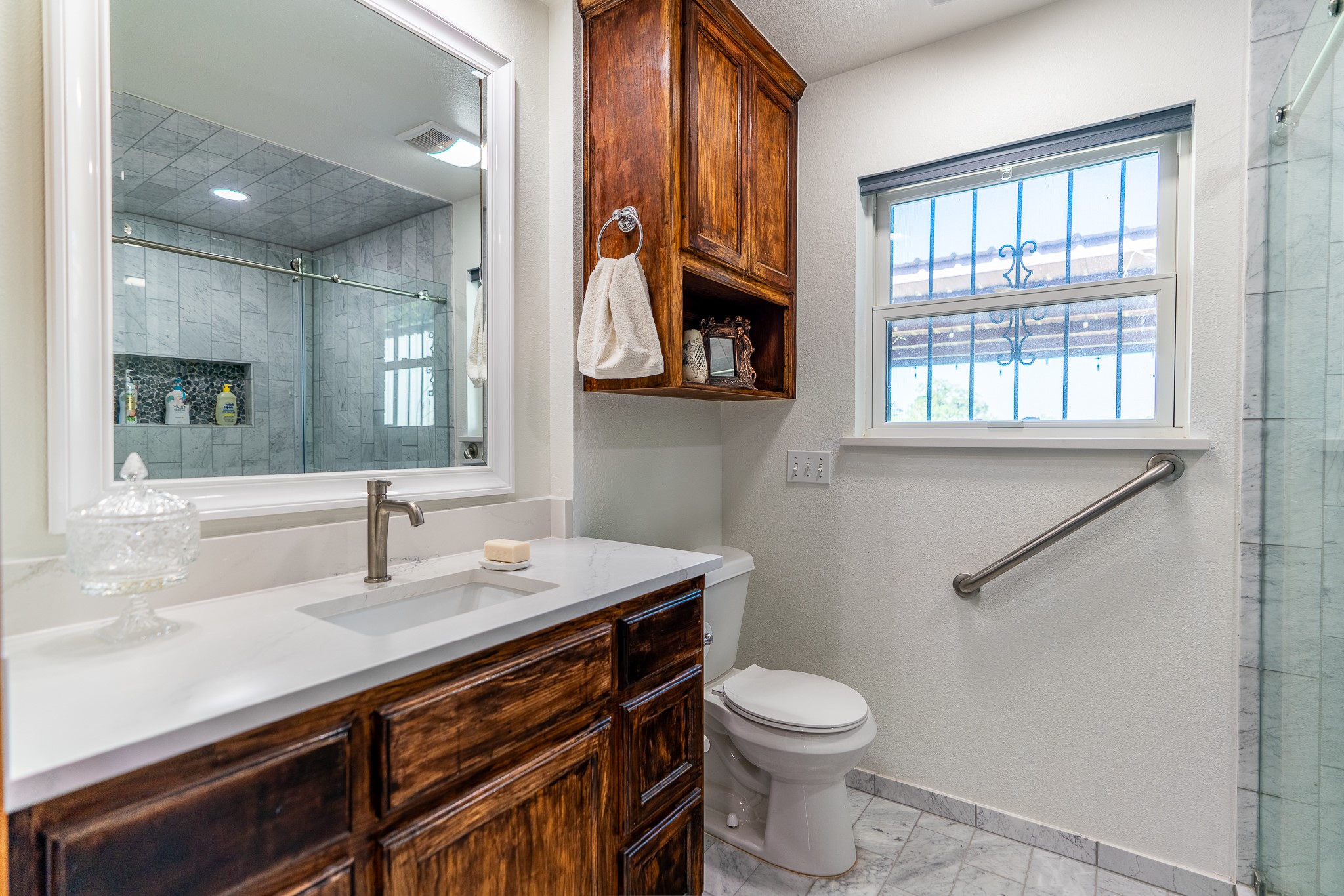 400 619th Spur Elgin, TX 78621 - Photo 28 of 40 White marble flooring and quartz countertops highlight this refreshed primary bathroom.