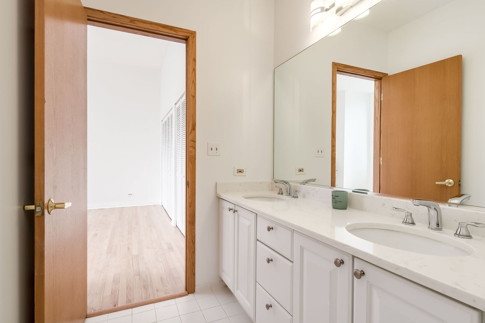 910 South Michigan Avenue, Unit 1908 Chicago, IL 60605 - Photo 16 of 29 a bathroom with a double vanity sink and a mirror