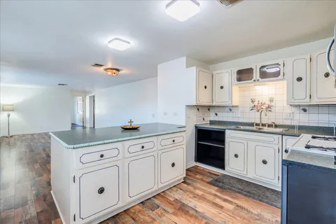 a kitchen with granite countertop white cabinets and white appliances