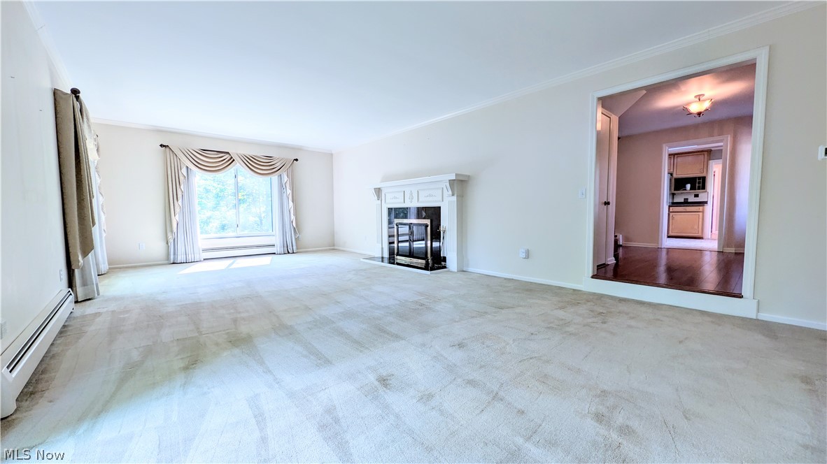 6409 Old Woods Road Ashtabula, OH 44004 - Photo 15 of 43 Carpeted living room featuring a white decorative fireplace, large window with valance and drapes, and crown molding