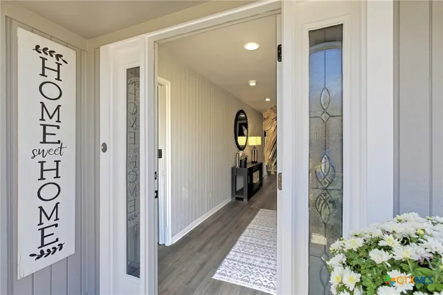 a view of hallway with livingroom and wooden floor