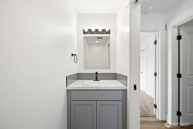 a bathroom with a granite countertop sink and a mirror