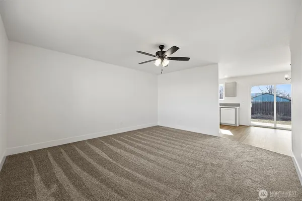 a view of empty room with wooden floor and ceiling fan