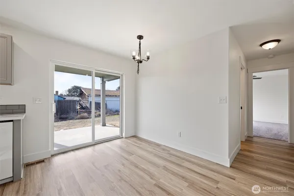a view of a big room with wooden floor and windows