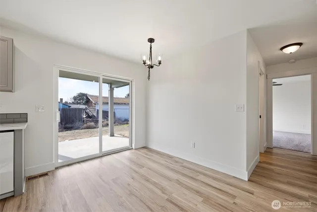 a view of a big room with wooden floor and windows
