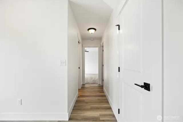 a view of a hallway with wooden floor